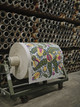 A collaged image set against a green background, showing Michal Silver, Creative Director, and Nina Luminati, Design Director, discussing wallpaper quality and production at Ivo’s printing factory. The collage includes scenes from the factory, production details, and colour swatches.